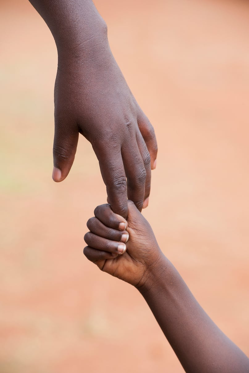 Female black hand holding a child